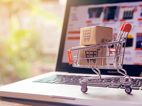 Laptop with a supermarket trolley and boxes for online shopping 